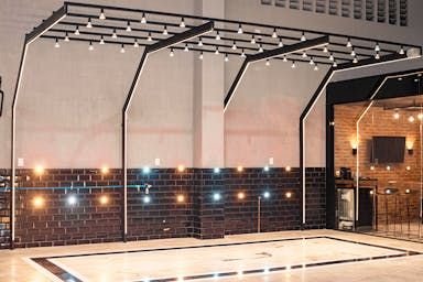 Box vazio com estrutura de LED no teto e piso demarcado