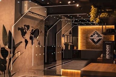 Recepção com mapa-múndi na parede e logo Avanzati iluminado