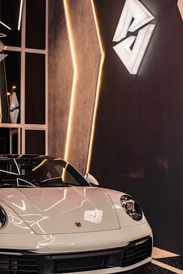 Porsche 911 branco ao lado do logo Avanzati iluminado