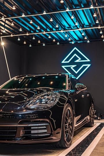Porsche Panamera preto sob o logo Avanzati em neon ciano